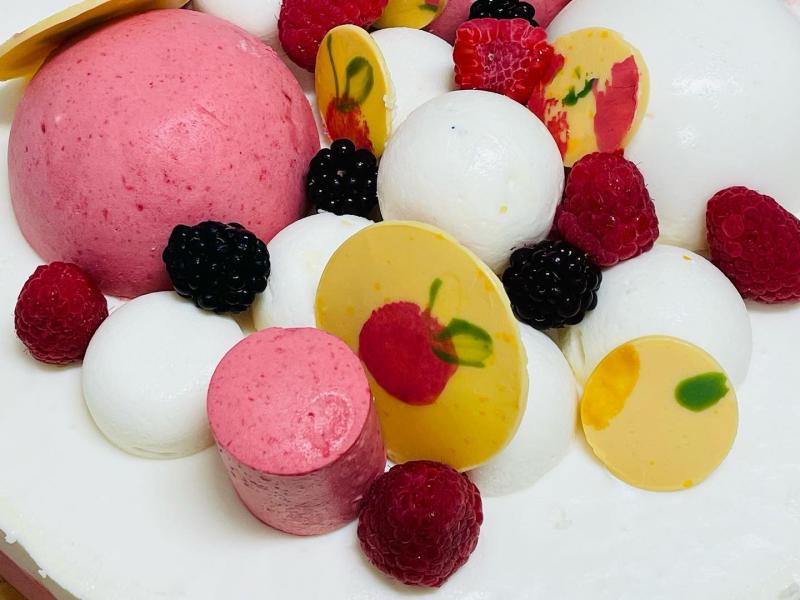 Vit kaka toppad med hallonmousse och frukter